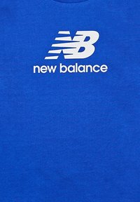 T-shirt in cotone blu con grande logo bianco "NB" e testo "new balance" sottostante, dal design classico a girocollo e texture liscia.