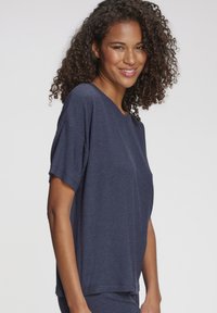 Marineblaues, geripptes T-Shirt mit kurzen Ärmeln, lockerem Schnitt und rundem Halsausschnitt, gefertigt aus weichem Stoff mit strukturierter Oberfläche.