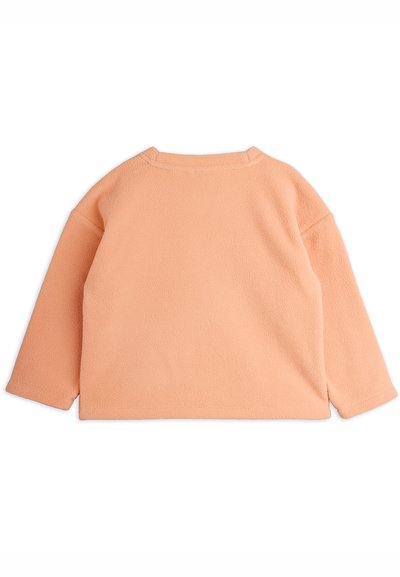 Pehmeä persikka-värinen pitkähihaine fleece-paita, jossa on suora helma ja hienovarainen tekstiilikuosi, nähtynä takaa.