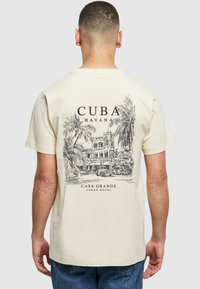 Béžové bavlněné tričko s černou grafikou historické kubánské budovy s palmami a textem "Cuba Havana Casa Grande."
