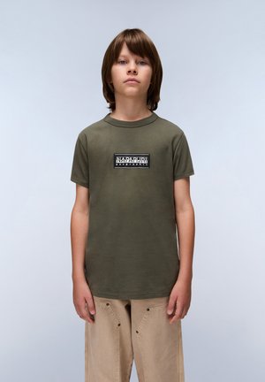 Olijfgroene katoenen t-shirt met korte mouwen, ronde halslijn en een logo op de voorkant met zwart-witte tekst. Casual fit.