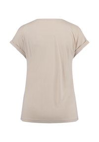 T-shirt beige à manches courtes avec un col rond et des manches retroussées, fabriqué en tissu doux, présentant une texture lisse et sans motifs.
