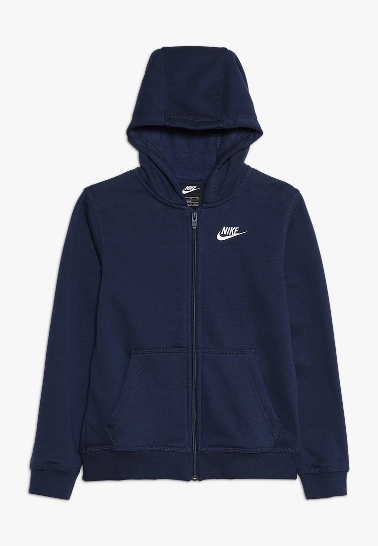 Námořnická modrá mikina na zip vyrobená z měkké tkaniny, která má přední kapsu, kapuci na stažení a bílé logo Nike na levém prsu.
