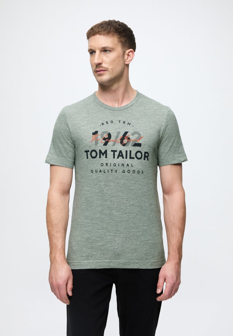 Πράσινη μπλούζα t-shirt με στρογγυλή λαιμόκοψη, κοντά μανίκια, με μαύρη και πορτοκαλί εκτύπωση κειμένου που περιλαμβάνει "TOM TAILOR" και "1942."