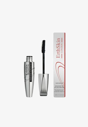 Silberner zylindrischer Mascara-Tube mit schwarzem Borstenapplikator daneben eine rechteckige weiße Box mit roten Akzentlinien und Produktdetails.