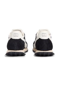 Αθλητικά παπούτσια με επάνω μέρος από μαύρο σουέτ και λευκό δέρμα, στρογγυλεμένο σχήμα, υφασμένους τόνους και λαστιχένια σόλα με πρότυπο πρόσφυσης.