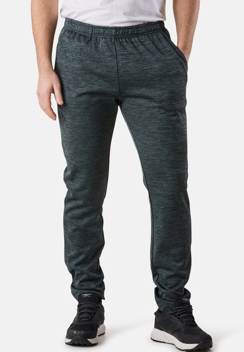 Dark grey athletic pants with a textured fabric, elastic waistband, and two side pockets, paired with black athletic shoes.