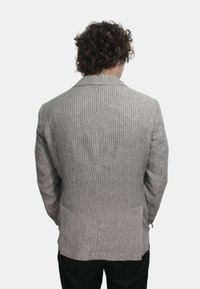 Blazer a righe grigio chiaro con vestibilità su misura, rever a punta e uno spacco sul retro; realizzato in un tessuto intrecciato per una maggiore texture.