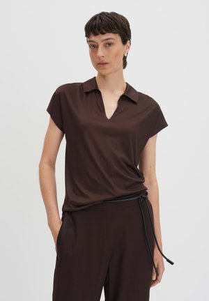 Brown cap-sleeve polo shirt with a v-neckline, made of soft fabric; paired with matching brown pants featuring a black drawstring belt.