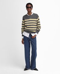 Grijze en crèmekleurige gestreepte trui met een ronde hals, gecombineerd met blauwe wijde jeans en zwarte puntige schoenen. Het model draagt een donkere zonnebril.