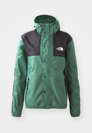 Giacca verde con accenti neri, realizzata in materiale leggero. Presenta un cappuccio, una cerniera e bottoni a pressione. Logo del marchio visibile sul petto.