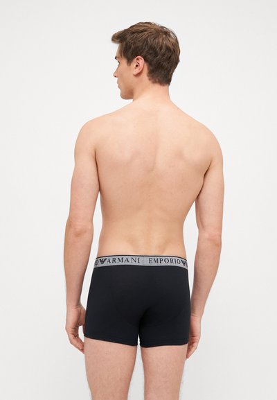 Čierne bavlnené boxerky s šedým pásom, na ktorom je logo "Emporio Armani". Hladká textúra a priliehavý strih.