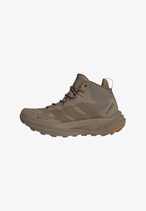 Brun Adidas Terrex trail løbesko med mellemhøjt skaft, Gore-Tex overdel, polstret sål og Continental gummiydersål for godt greb.