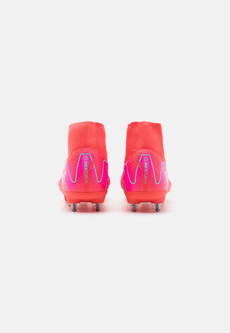 Des crampons de football rouges et roses avec un design texturé, une silhouette basse et des pointes coniques pour l'adhérence. Comprend un logo sur le talon.
