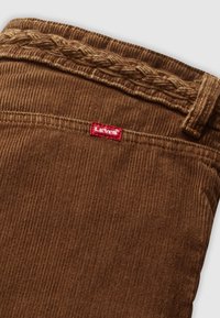 Bruine corduroy broeken met een gevlochten tailleband, voorzien van een rode Levi's logo label en een gestructureerde reliëf op de stof.