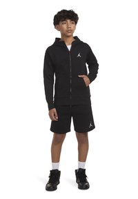 Μαύρη φούτερ ζακέτα με φερμουάρ και σορτς με λευκό λογότυπο Jordan. Περιλαμβάνει τσέπες καγκουρό, ριμπ στα μανίκια και χαλαρή εφαρμογή. Υφή υφάσματος.