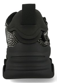 Chaussure de sport noire avec un dessus texturé, décorée d'accents métalliques argentés. Dispose d'une languette à l'arrière pour un enfilage facile.