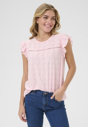 Top rosa a maniche corte con dettagli in pizzo, maniche arricciate e scollatura rotonda, abbinato a jeans in denim blu.