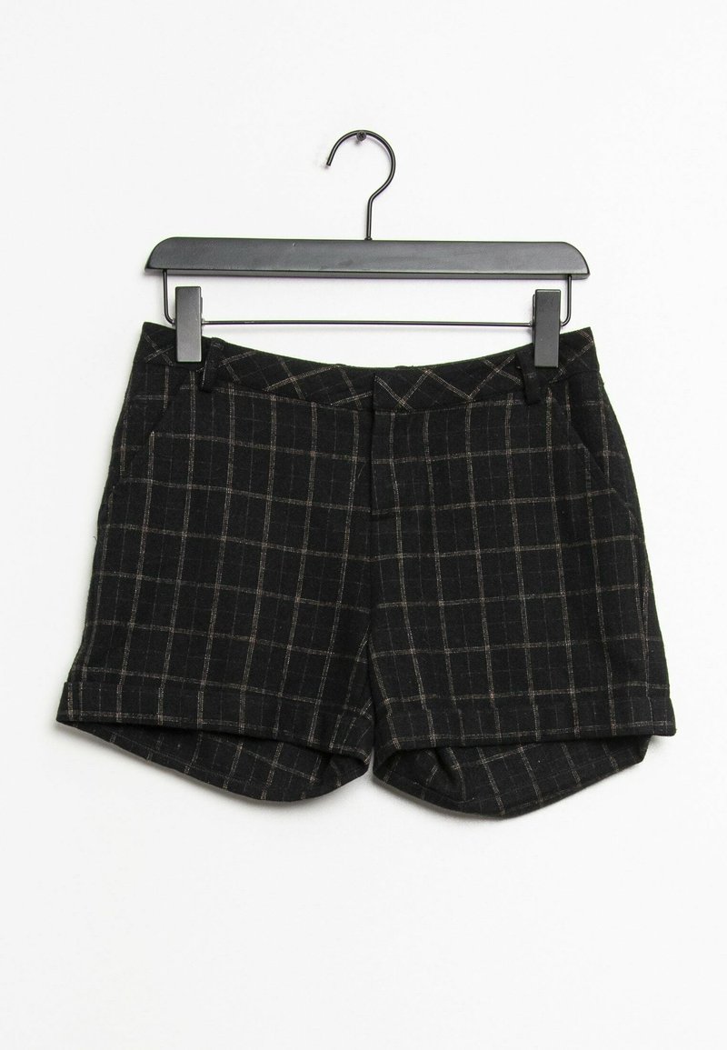 Svarta shorts med rutmönster, gjorda av texturerad tyg, med framfickor och en lätt uppvikt fåll, hängande på en svart galge.