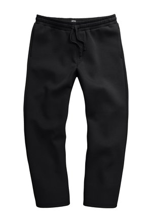Schwarze Sweatpants aus weichem Stoff, mit einem Kordelzugbund, seitlichen Taschen und einem schmal zulaufenden Bein Design.