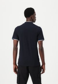 Marine polo shirt met witte accenten langs de kraag en mouwen; ontwerp met korte mouwen, gemaakt van gladde katoenstof.
