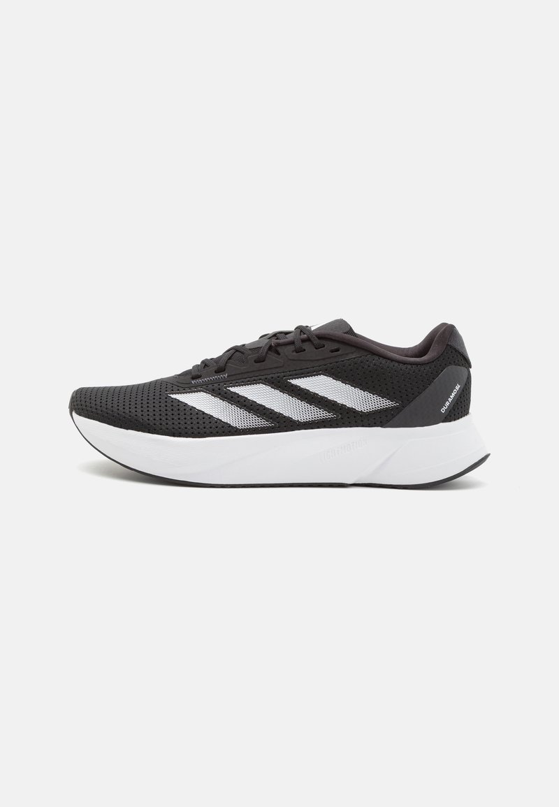 Scarpa sportiva nera con tomaia in rete, tre strisce bianche lateralmente, una suola intermedia bianca imbottita e un design elegante e arrotondato.