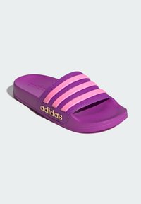 Fioletowa klapka z trzema różowymi paskami na wierzchu. Posiada teksturowaną, syntetyczną podeszwę oraz złote logo po boku.