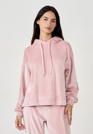 Różowa welurowa bluza z luźnym krojem, kapturem na sznurku i długimi rękawami. Miękka tekstura i minimalistyczny design z prostym dołem.