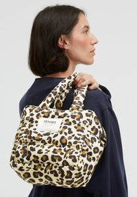 Beige and brown leopard print tote bag with padded design and two short handles, featuring a label on the front.