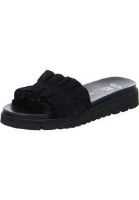 Black slide sandal featuring a ruffled detail on the strap, soft fabric upper, thick textured sole, and a rounded toe design.