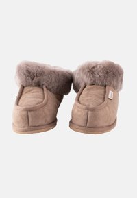 Chaussons en daim marron avec un revers en fausse fourrure grise duveteux, de forme arrondie et semelles plates, conçus pour le confort et la chaleur.