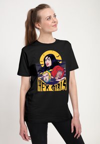 Czarna koszulka z graficznym nadrukiem trzech postaci z kreskówek o kolorowych włosach na tle żółtego księżyca. Napis brzmi "HEX GIRLS."