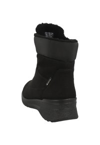 Botas de tobillo de ante negro con un suave y esponjoso collar y suela de goma. Presenta una etiqueta GORE-TEX impermeable en el lateral.