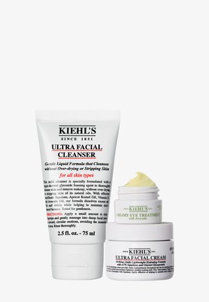 Kiehl’s Ultra Facial Cleanser-tube ved siden af Ultra Facial Cream-krukke med Creamy Eye Treatment på toppen, alle hvide med sort og grøn tekst.