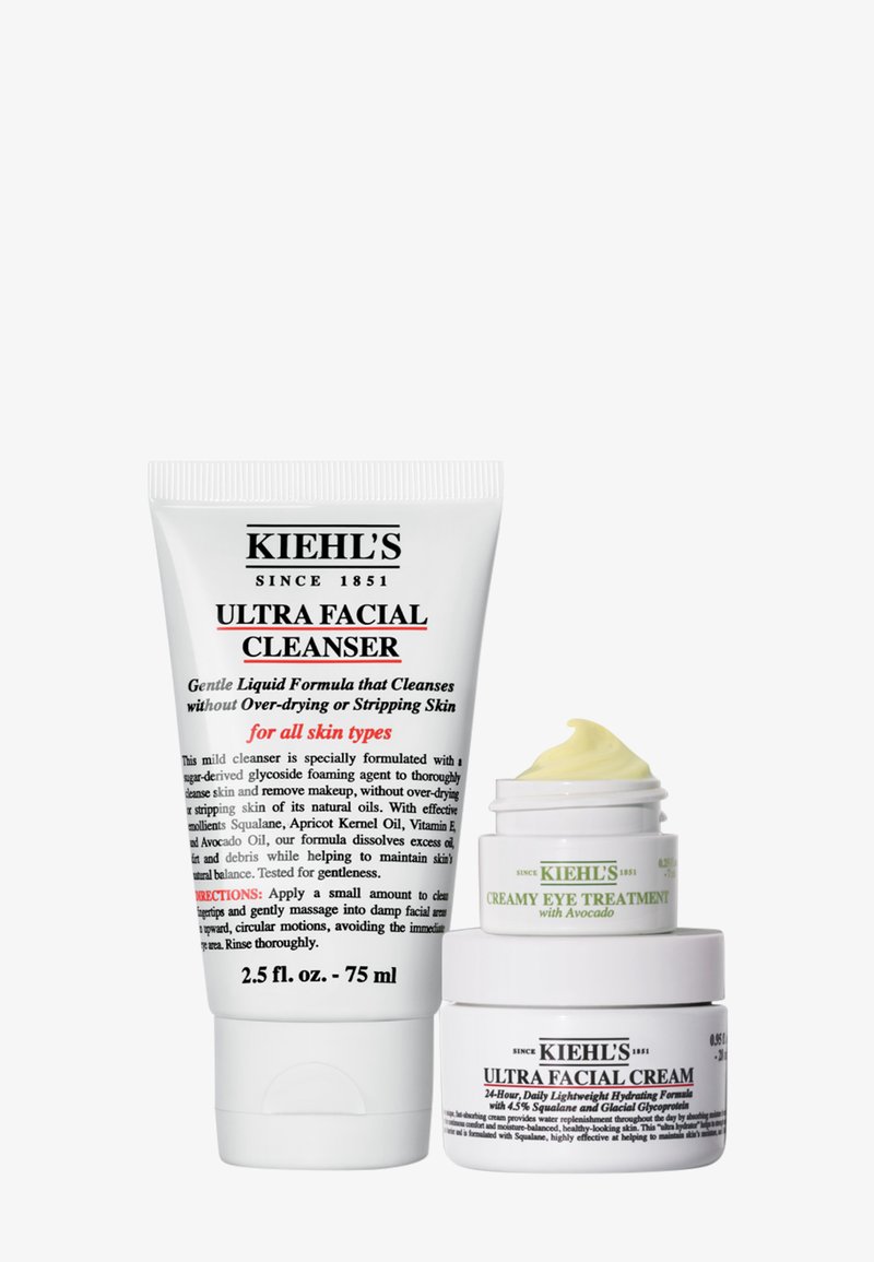Kiehl’s Ultra Facial Cleanser tube beside Ultra Facial Cream jar topped with Creamy Eye Treatment, all white with black and green text.