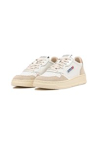 Sneakers bianchi e beige realizzati in suede e pelle, con un motivo perforato sulla punta, design con lacci e una suola testurizzata.
