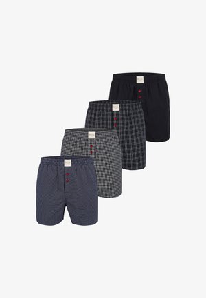 Vier herenboxershorts met blauwe en zwarte patronen, elk voorzien van een label en drie rode knopen op de voorste tailleband, in een rij gerangschikt.