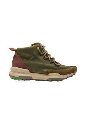 Zapato de senderismo verde y marrón con suela beige salpicada, cordones marrones, ojales de metal y suela verde sobre fondo blanco.