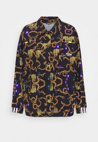 Svart skjorta med en guldchain och djurmönster, med blåa och röda accenter. Designad med knappar och vita randiga manschetter.