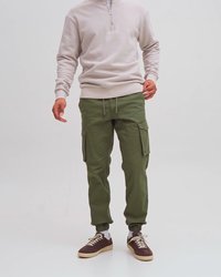 Pantalons cargo couleur khaki avec poignets élastiques et plusieurs poches, associés à un sweatshirt zippé beige clair et des baskets marron.