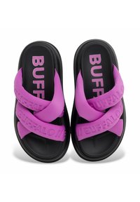 Lila gummiskor med korsade remmar och svarta sulor. Har präglad "BUFFALO" text på remmarna. Slät yta, platt design.