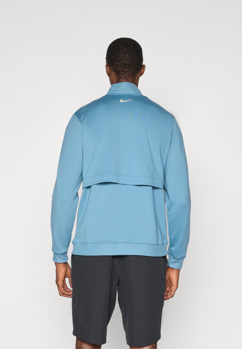 Sweatshirt Nike blu con colletto, maniche lunghe e design a strati. Presenta un piccolo logo bianco sul retro e una texture morbida.