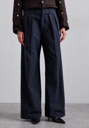 Navy wide-leg trousers, pleated front, cotton blend material, high waist, with black pointed shoes, textured fabric, and clean lines.