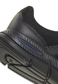 Black athletic shoe heel with textured sole and "Cloudfoam Flex" label on cushioned midsole.