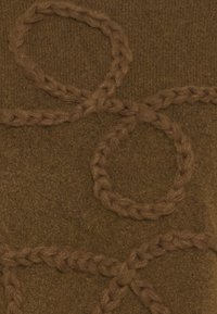 Tessuto a maglia marrone con anelli intrecciati e modelli intrecciati in rilievo, creando un design testurizzato e stratificato.