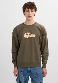 Sudadera verde oliva con mangas largas y cuello redondo. Presenta un logo melocotón "Inside" en el pecho, en una tipografía audaz y moderna.