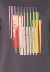 Graues T-Shirt mit einem geometrischen Design aus vertikalen und horizontalen Streifen in verschiedenen Schattierungen von Lila, Grün, Rot und Orange.