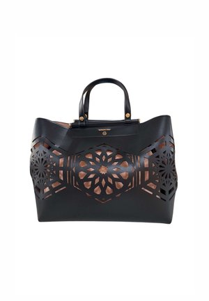Borsa in pelle nera con due manici, con motivi floreali ritagliati simmetrici che rivelano una fodera interna marrone.