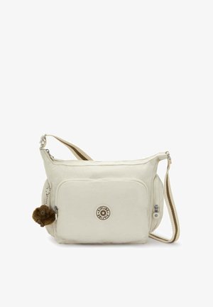 Beige Kipling shoulder bag with adjustable striped strap, front zip pocket, branded circular logo, and small brown monkey keychain charm.