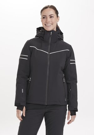 Svart vattentät jacka med dragkedja framtill, justerbar huva och reflekterande vita detaljer. Har två sidofickor och manschetter vid handlederna.